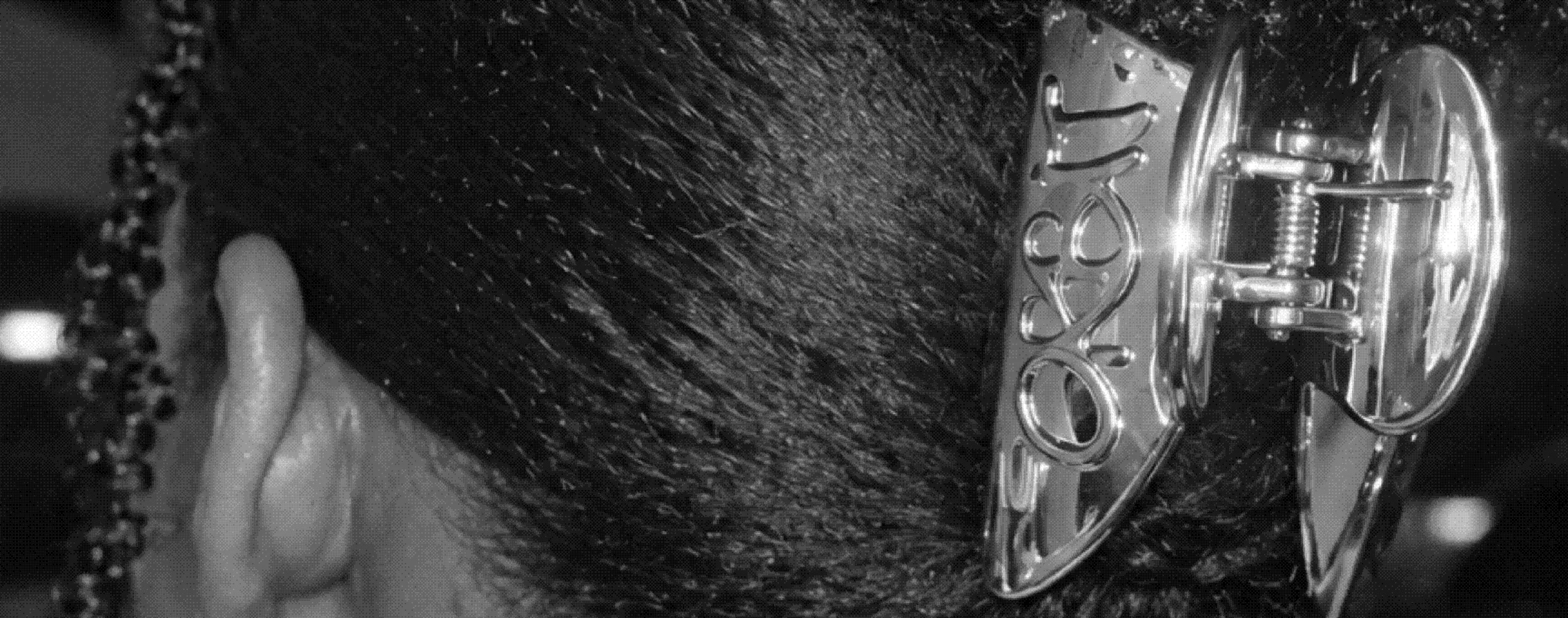 A chrome ORBIT hair claw holding back dark hair